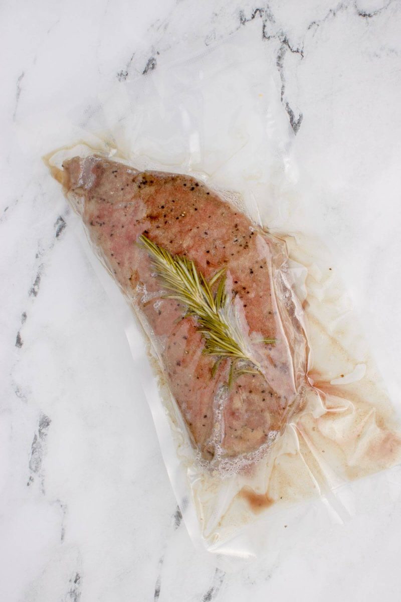 London broil is in a plastic bag sous vide with rosemary.