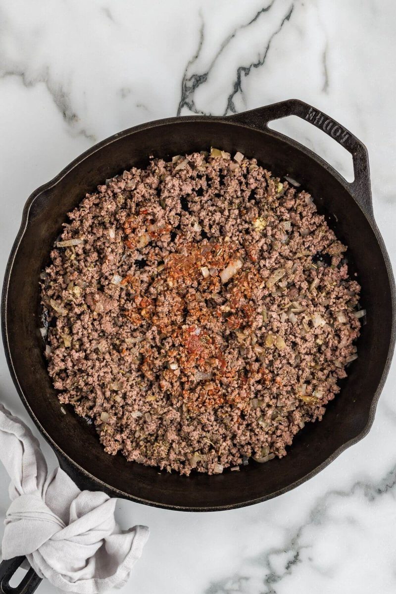 Reddish brown seasonings coat the center of the pan of ground beef mix.