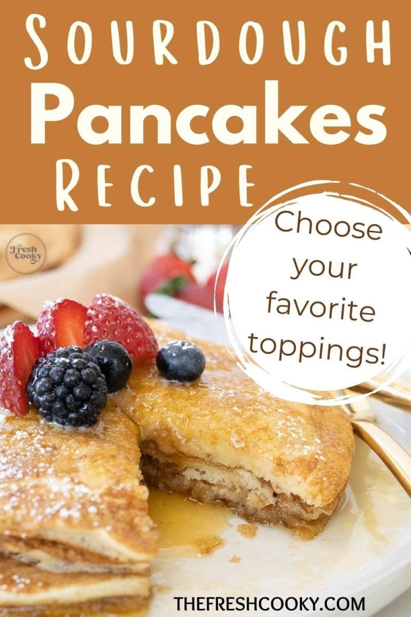Short stack of pancakes with berries on top has a sliver missing and shows fluffy insides, to pin.