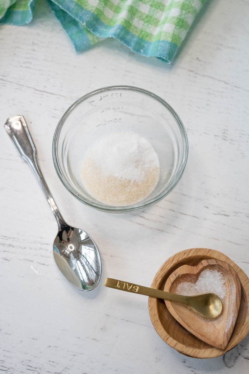 A small glass bowl holds salt, baking soda, and sugar for recipe.