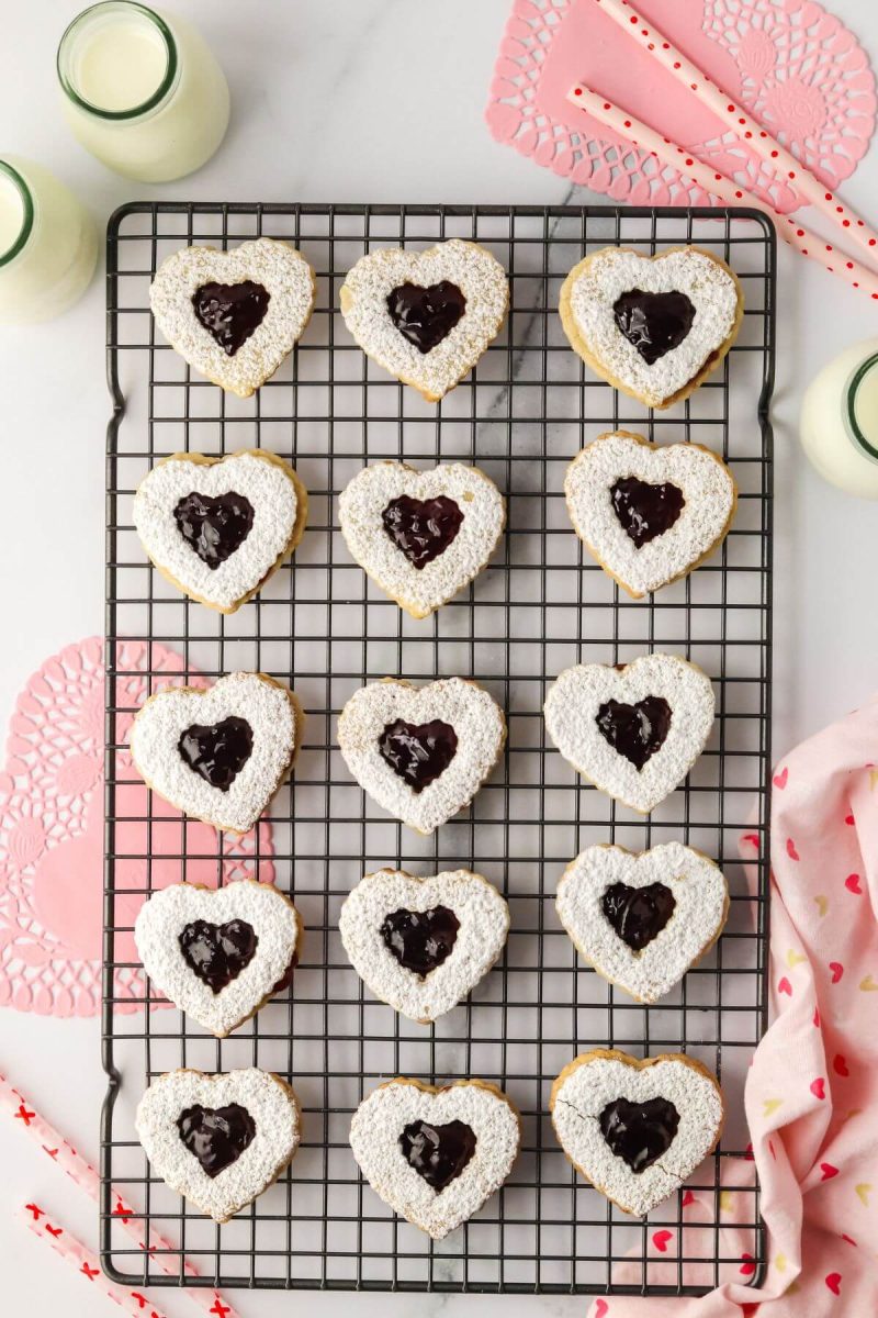 Completed heart shaped cookies sit on wire rack.