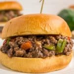 Philly cheesesteak sloppy joe mixture on brioche buns with wooden pick.