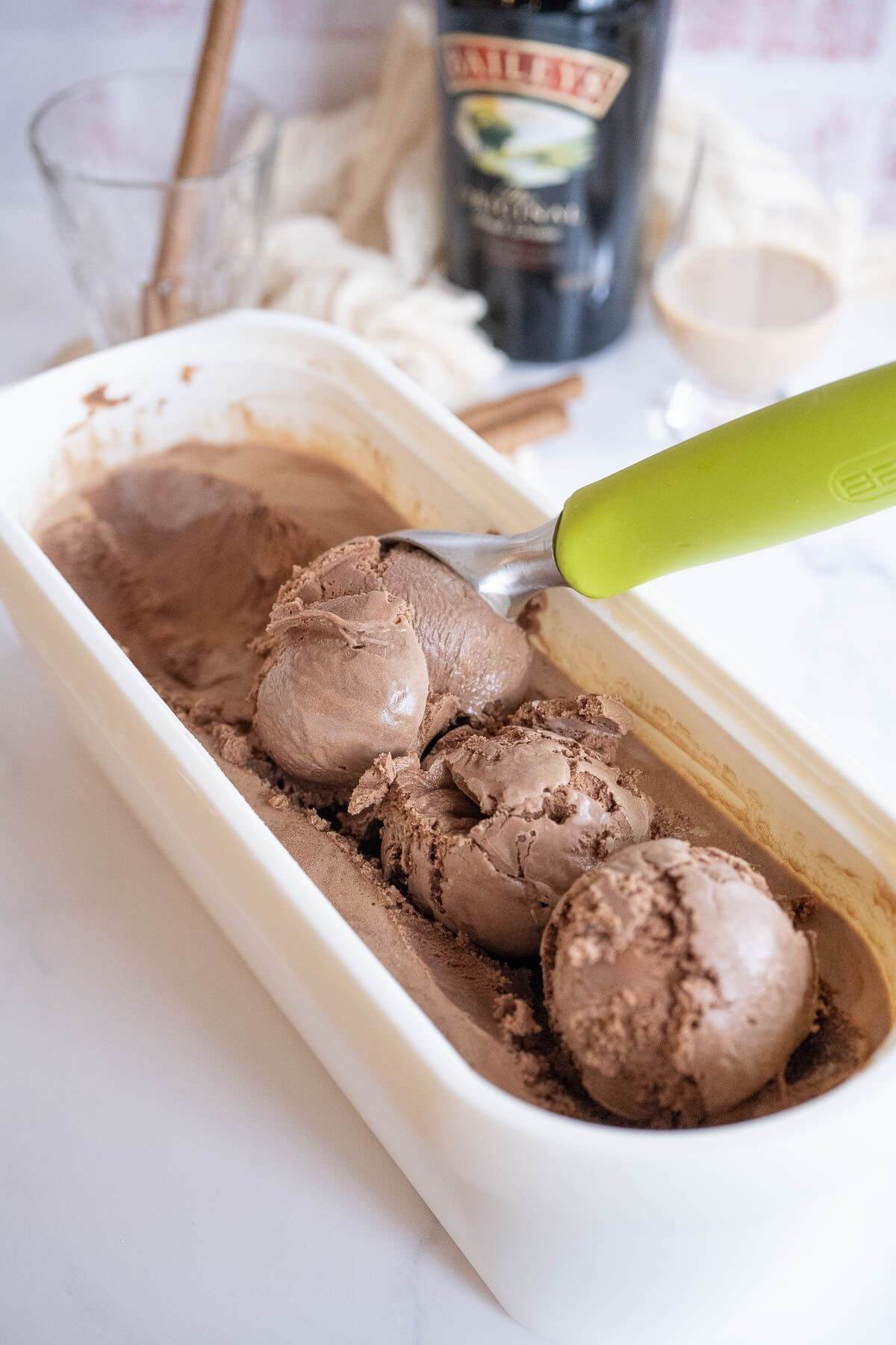 An ice cream scoop deposits a round glob.