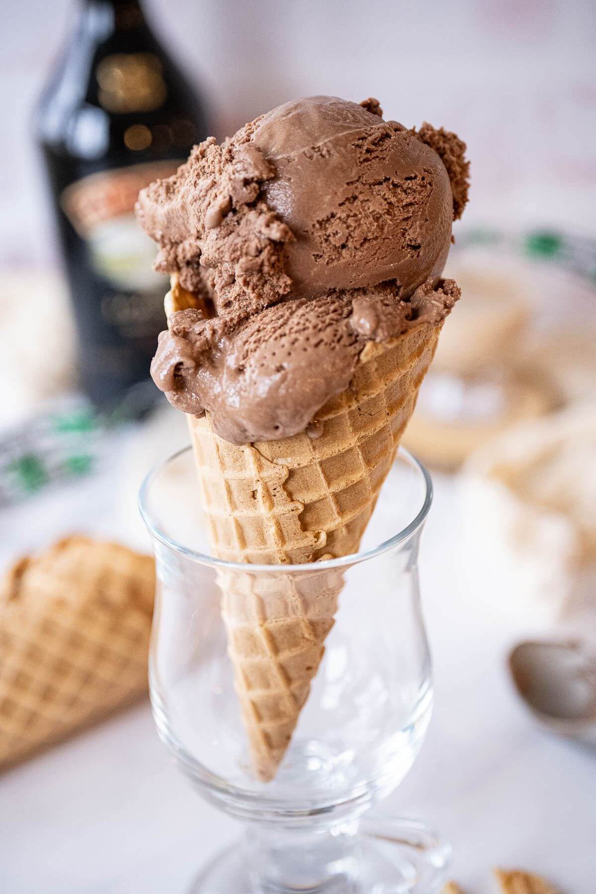 A cone full of ice cream scoops stand up in a clear glass for display.