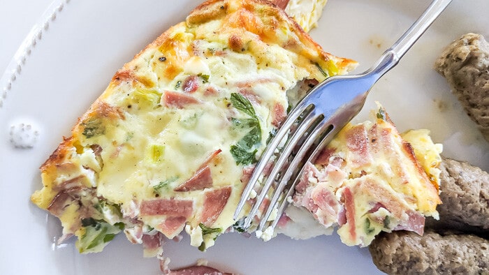 Baked leftover ham omelete with a fork taking a bite.