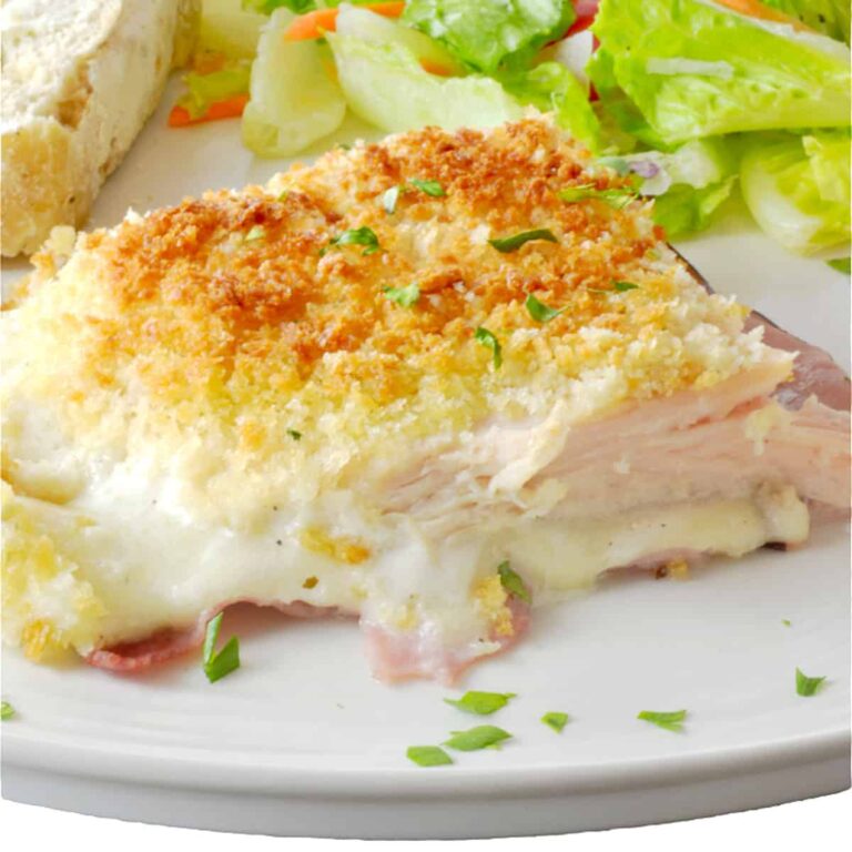 Chicken cordon bleu casserole slice on a plate with salad.