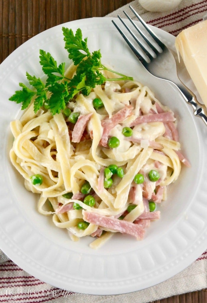 Fettuccine alfredo with ham, peas and parsely.