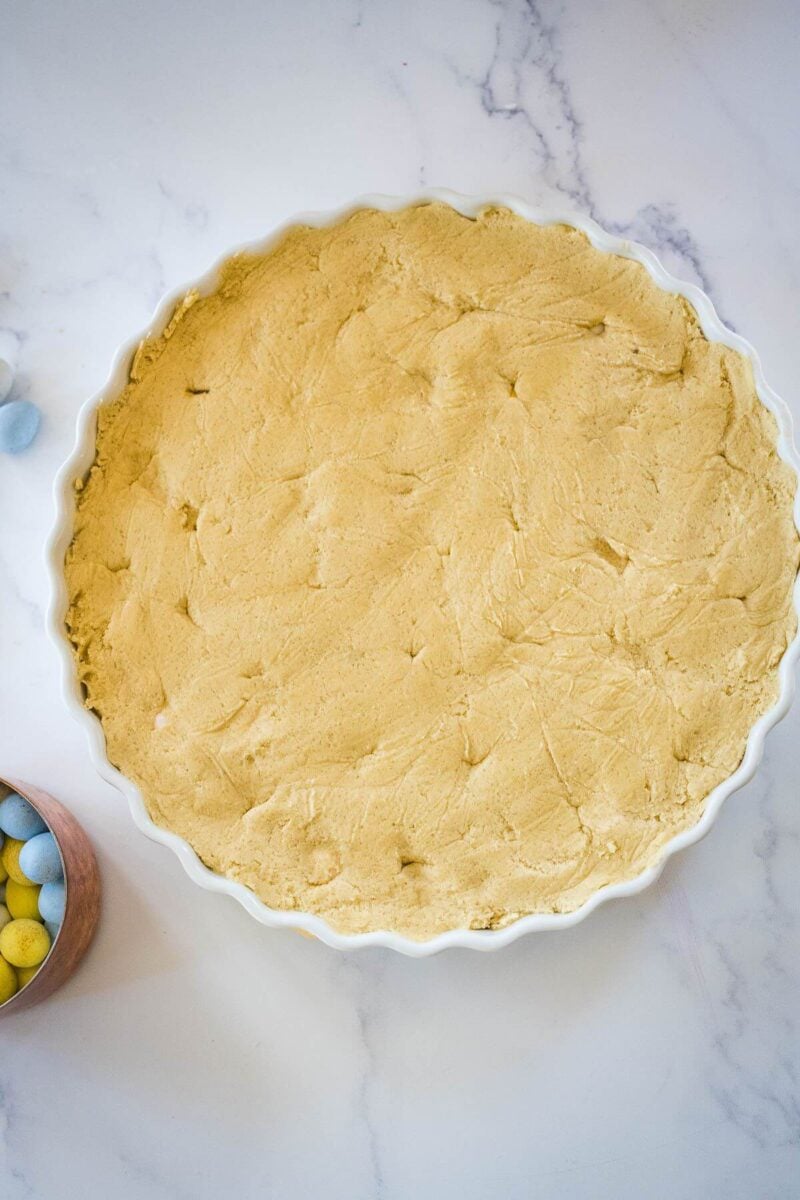 A tart dish is full of cookie batter.