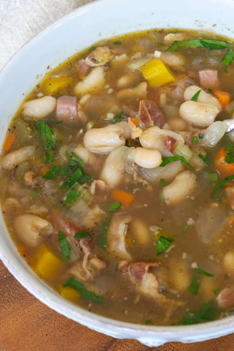Ham and bean soup in a white bowl.