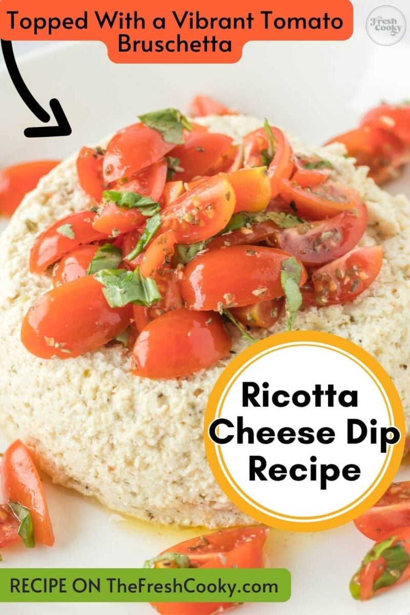 Tomato, fresh basil, and herbs top a mountain of baked cheese dip on a plate, to pin.
