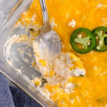 Spoon in glass dish scooping up Jalapeno corn casserole.