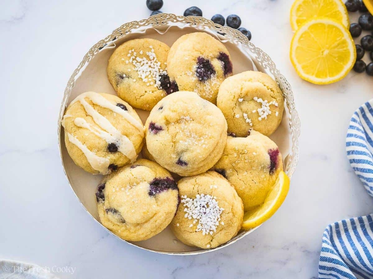 Looking down on a pretty scalloped tray filled with lemon blueberry cookies.