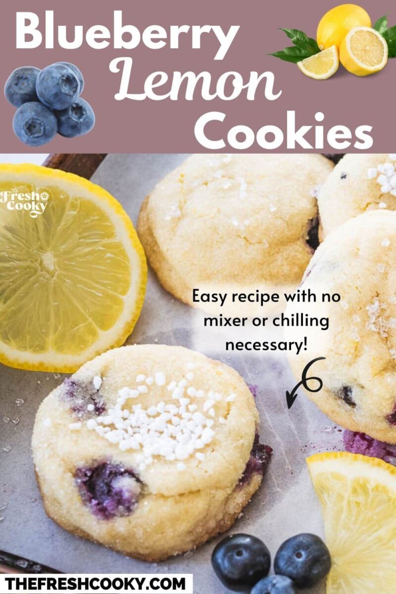 Lemon blueberry cookies on cookie sheet sprinkled with sugar and a lemon slice nearby - to pin.