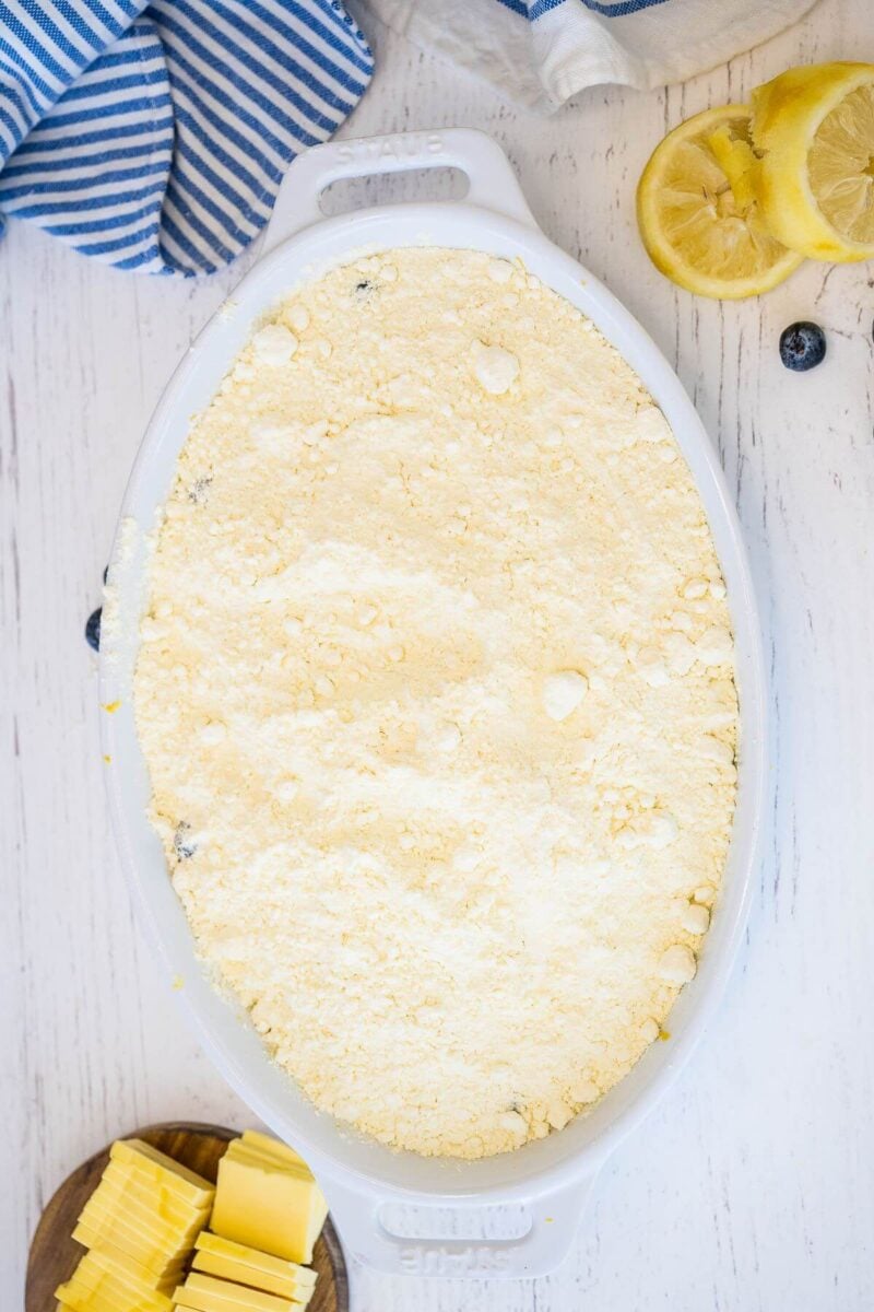 A baking dish is completely covered with cake mix.