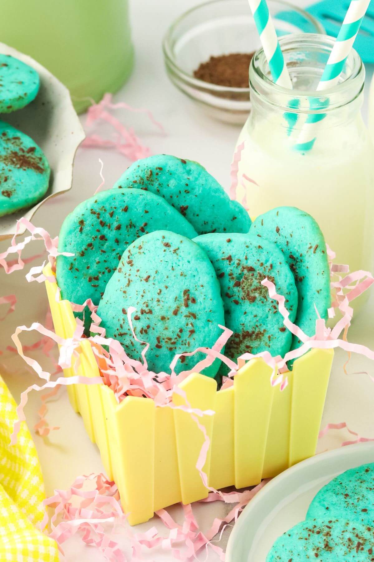 Robins egg slice and bake sugar cookies in Easter basket with pink grass shreds.