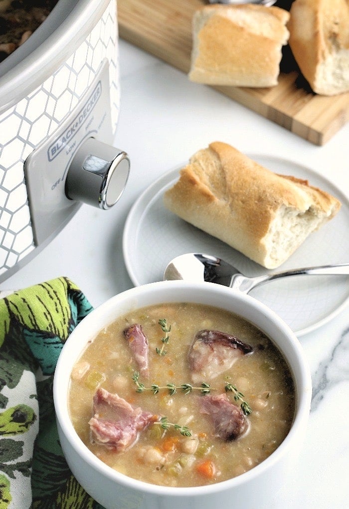 Crockpot in background of ham and bean soup.