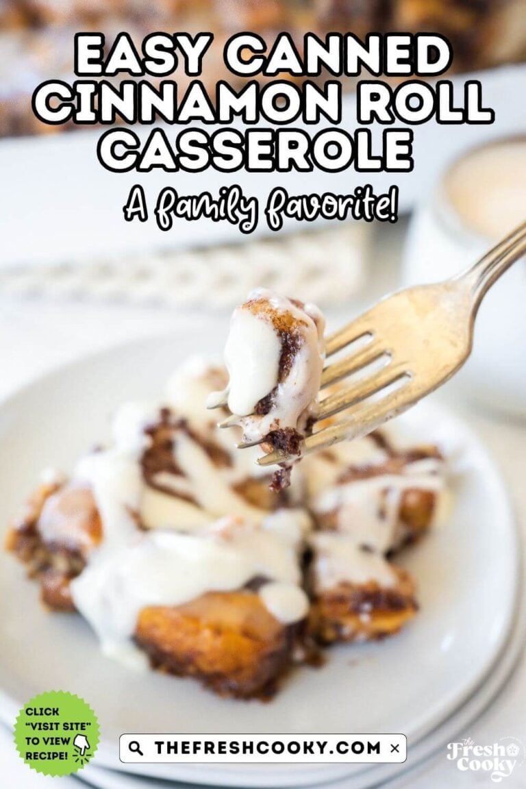 A fork holding up a bite of gooey cinnamon roll casserole, served on a white plate topped with frosting, to pin.