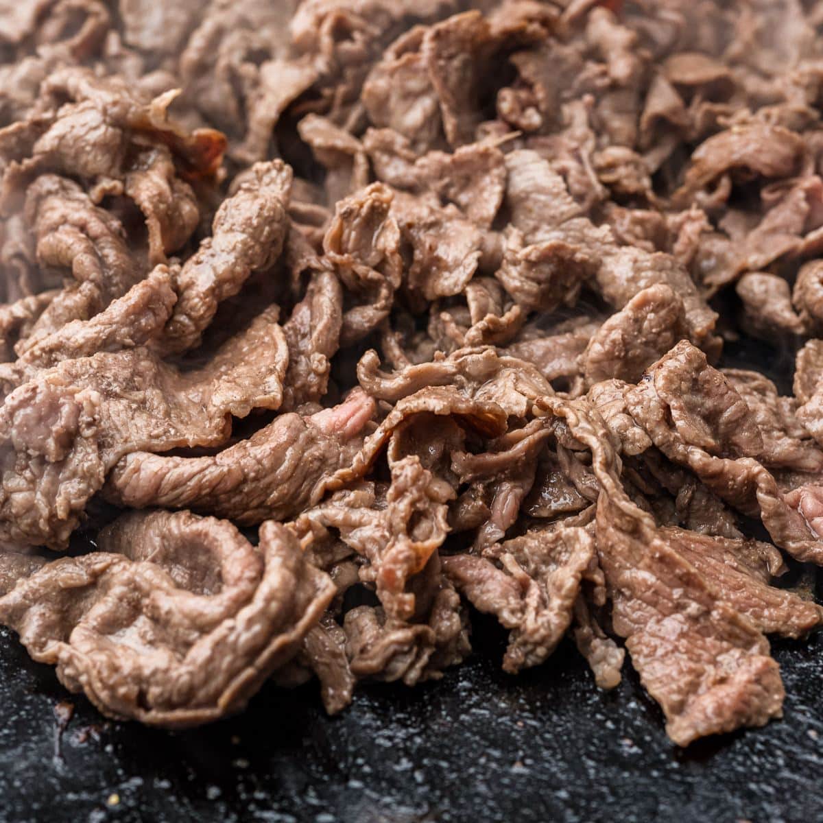 Browned shaved steak on Blackstone flat-top griddle. 