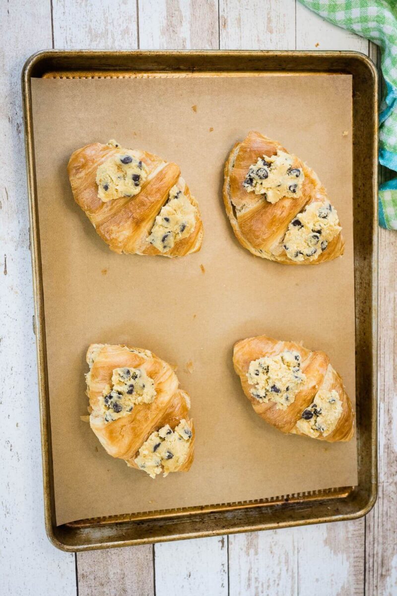 Cookie Croissants with cookie dough on top on baking sheet. 