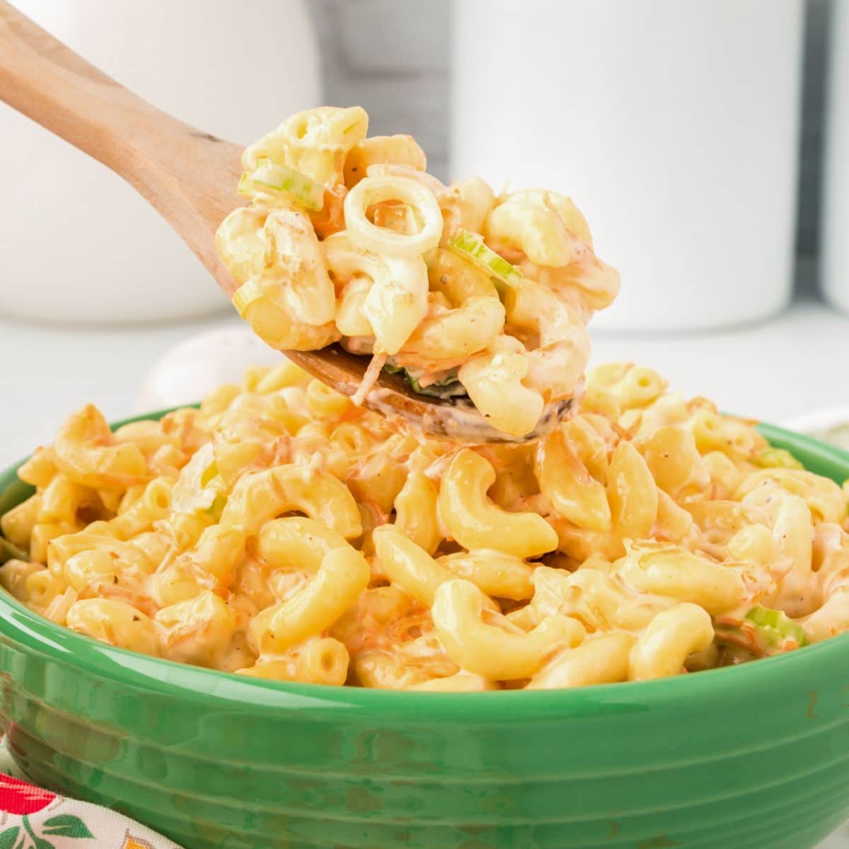 A large green bowl filled with creamy Hawaiian macaroni salad.