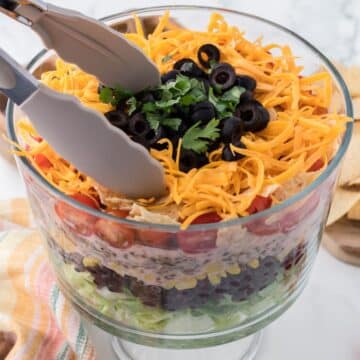 Tossing taco salad in bowl.