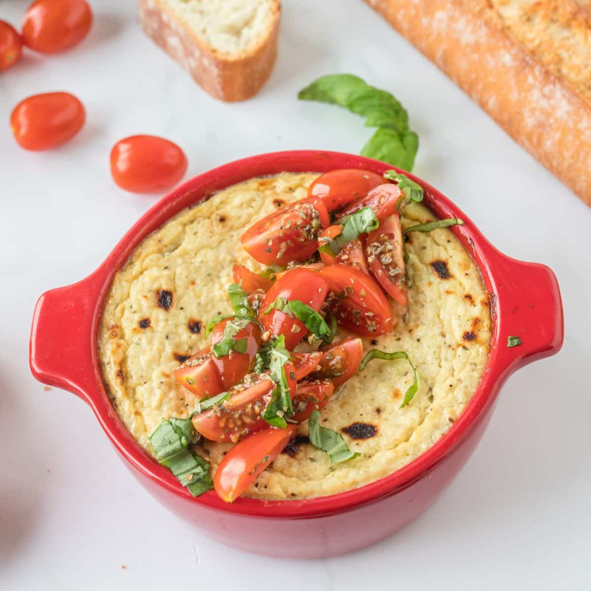 Ricotta Cheese Dip in baking dish topped with tomato bruschetta.