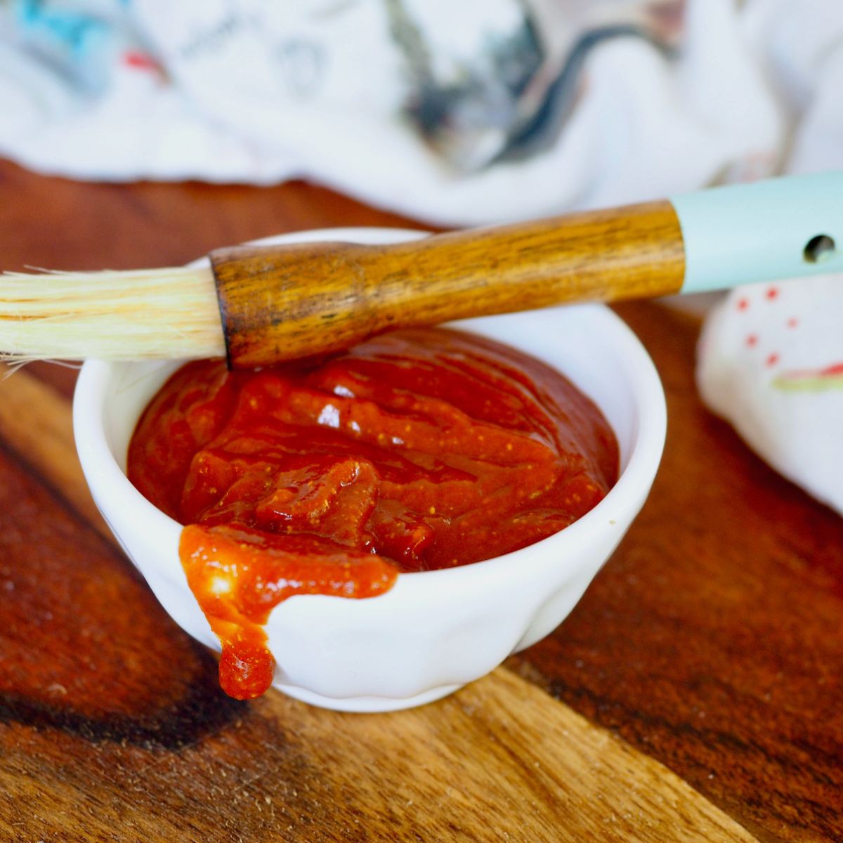 A bowl full of Rocky Mountain Barbecue Sauce with a basting brush.