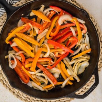 Sauteeing onions and peppers in a cast iron skillet.