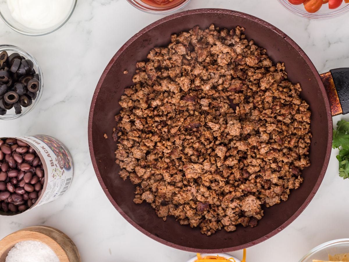 Browned and seasoned ground beef in a skillet.