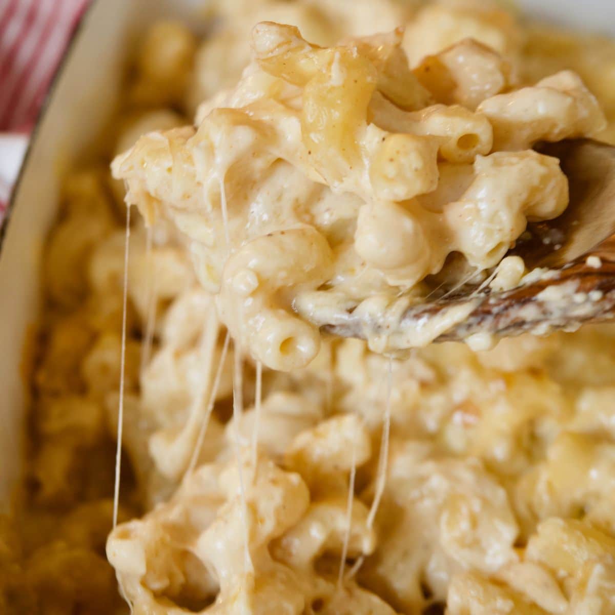 Smoked mac and cheese with stringy cheese pulling from a spoon.