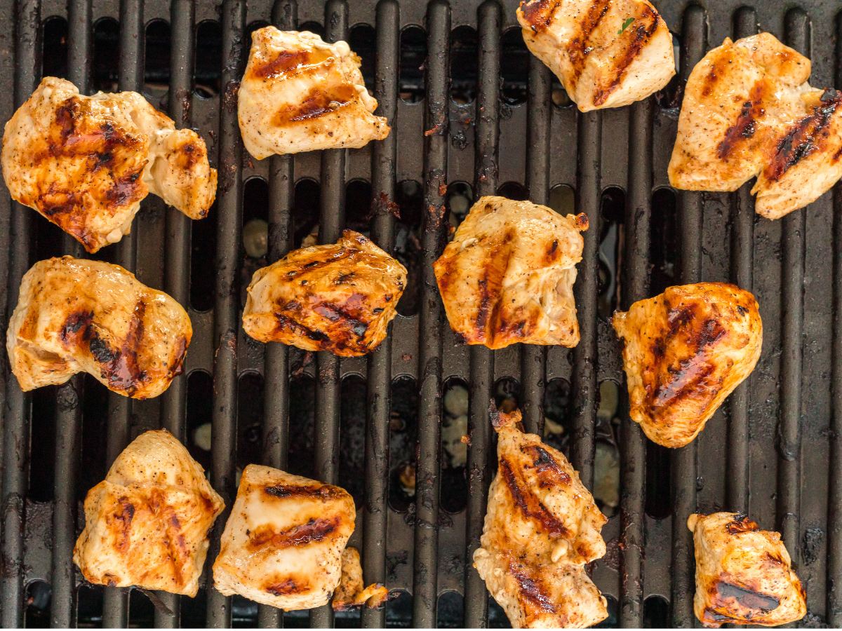 Chicken nuggets with grill marks on grill grate.