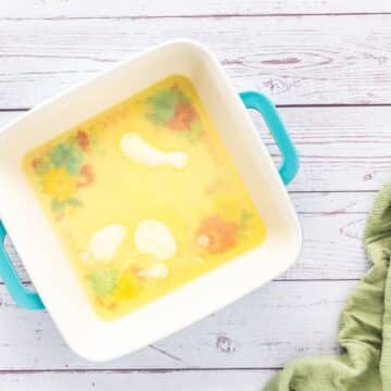 Melted butter rests in the bottom of a square pan.