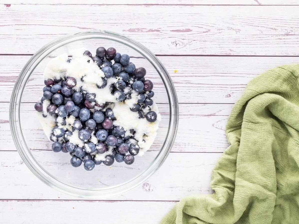 Sugar tops a bowl of fresh blueberries.