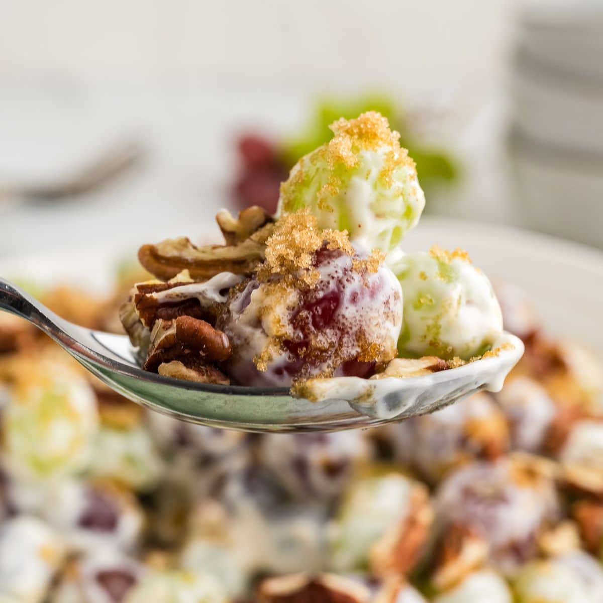 Chicken salad chick grape salad recipe with serving of creamy grape salad on a spoon.