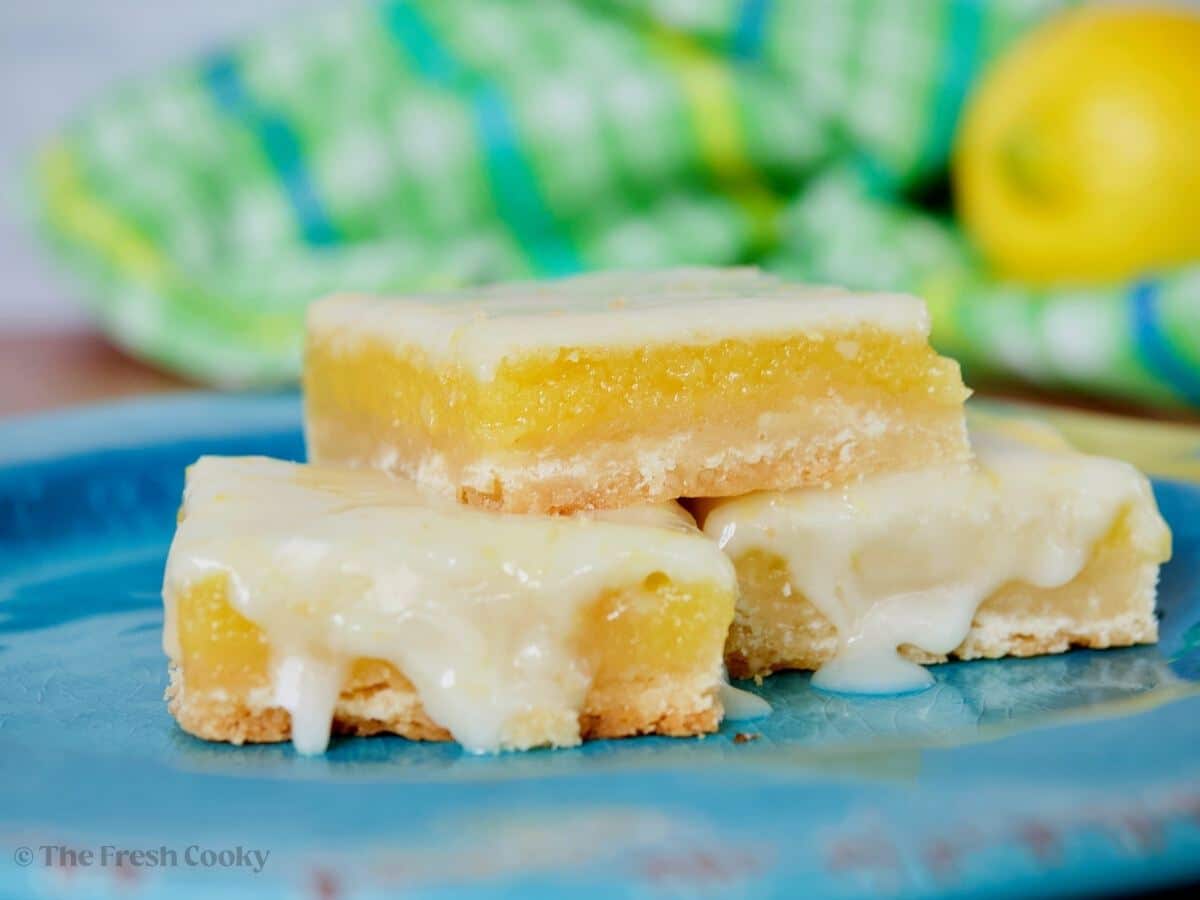 Lemon squares on a plate with oozy glaze.
