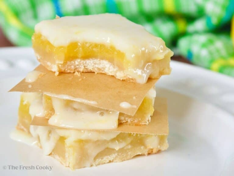 Lemon squares, stacked with a bite taken out.