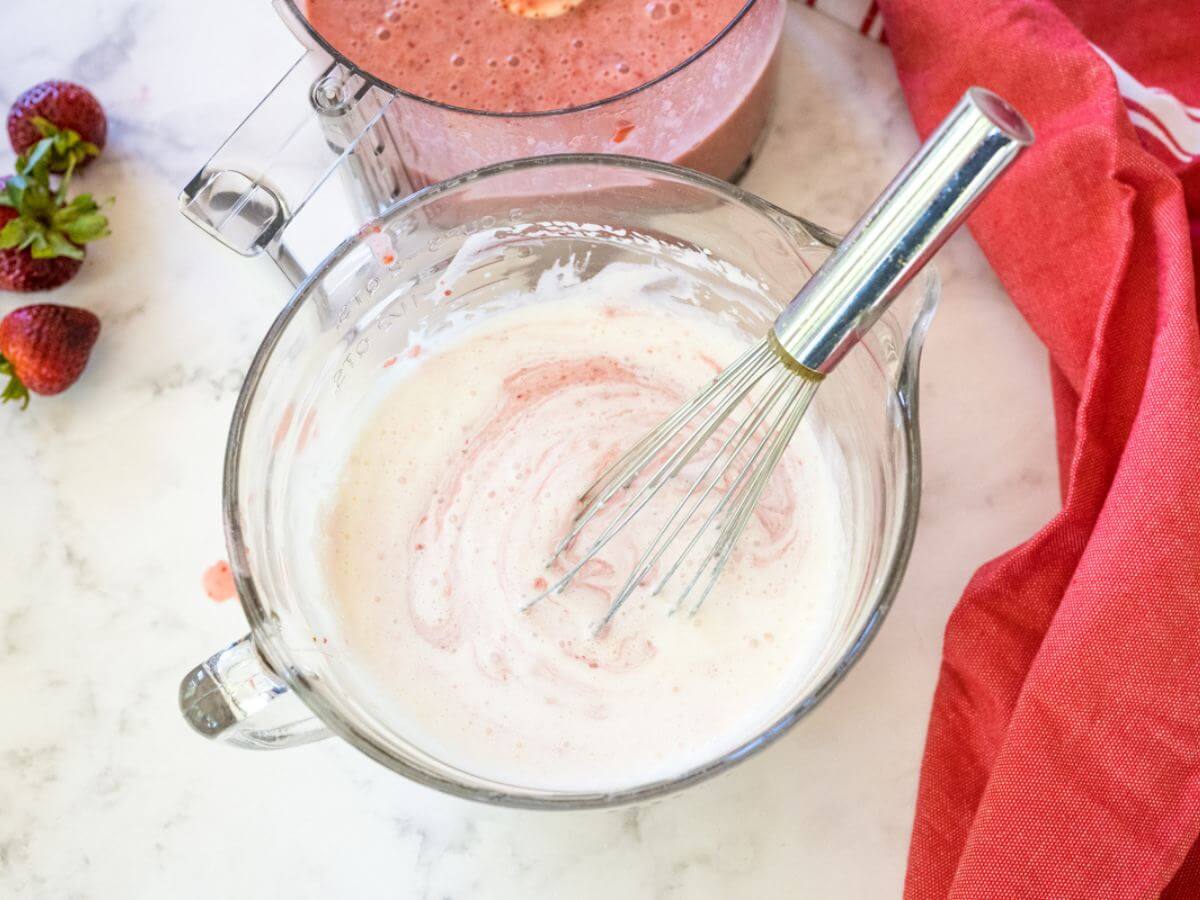 Whisking heavy cream in bowl.