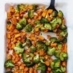 A pan of sweet potatoes and broccoli with a serving spatula.