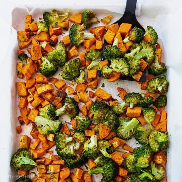 A pan of sweet potatoes and broccoli with a serving spatula.