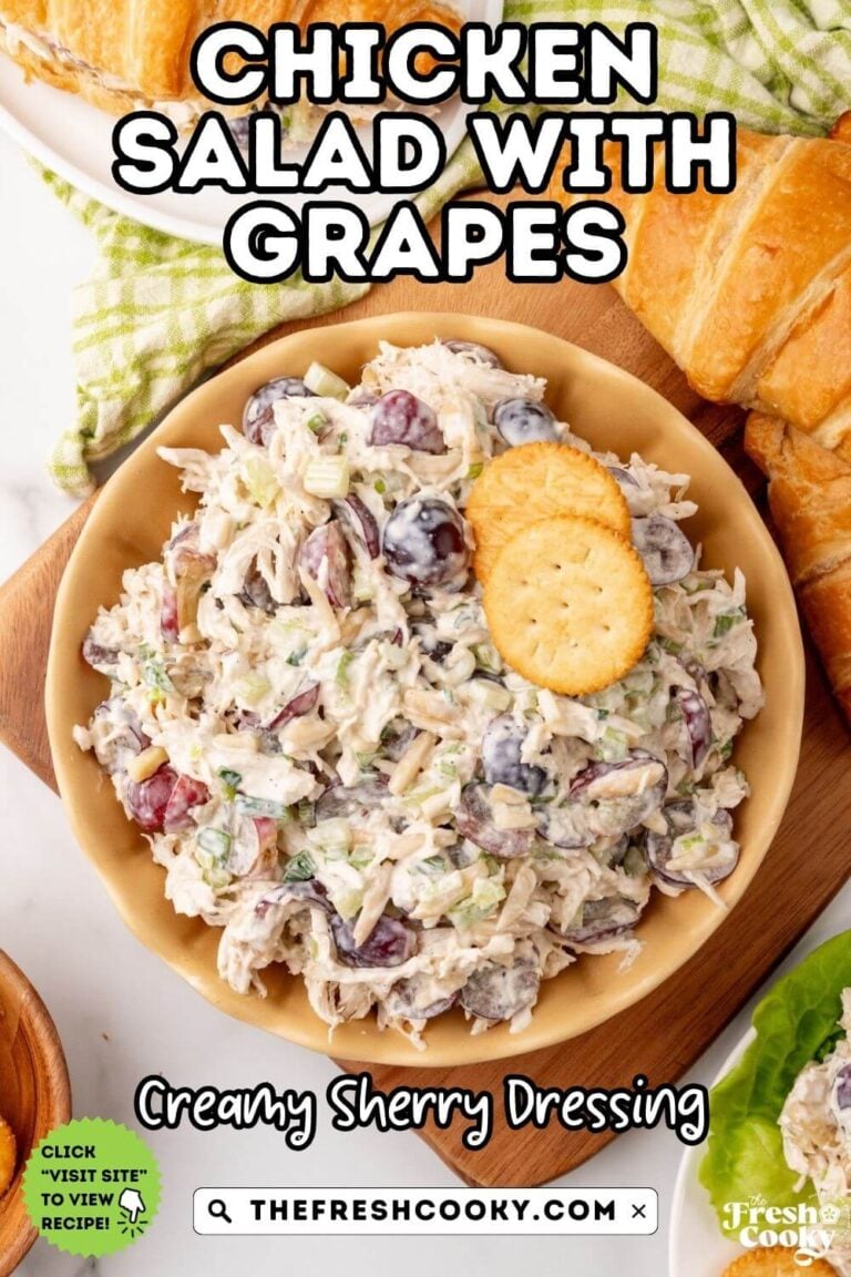 Chicken salad with grapes in a bowl surrounded by croissants, crackers and lettuce. For pinning.