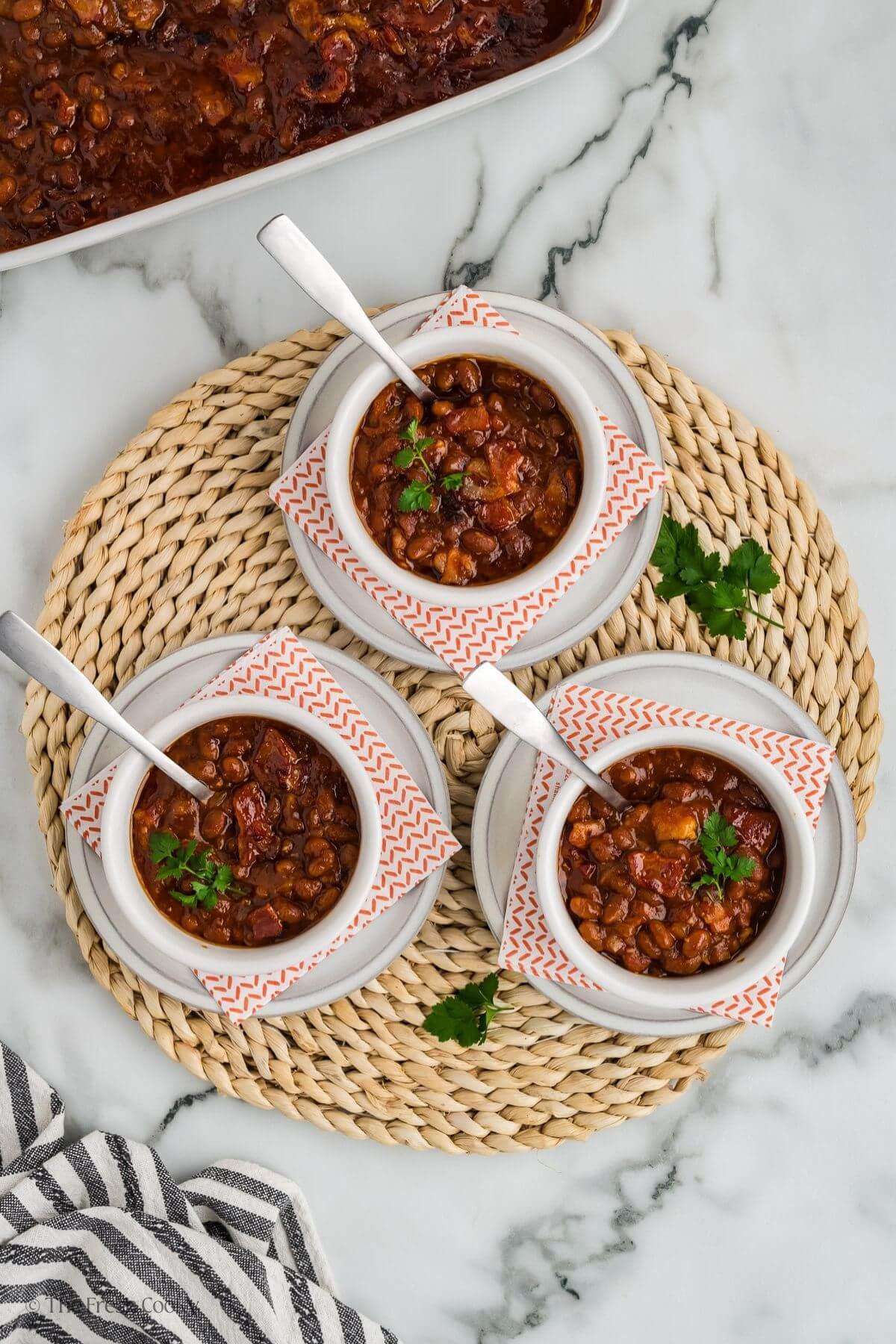 3 serving bowls filled with cowboy baked beans. 