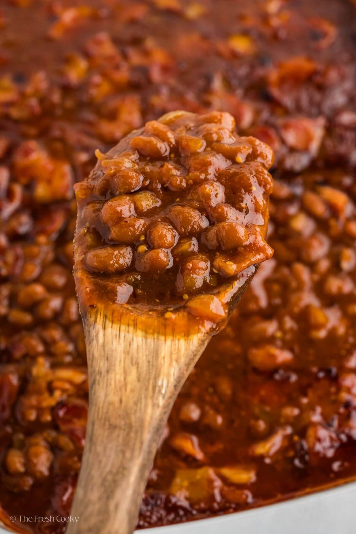 A wooden spoonful of cowboy baked beans. 