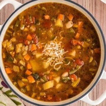 Minestrone soup after it is done cooking and garnished with parmesan cheese.