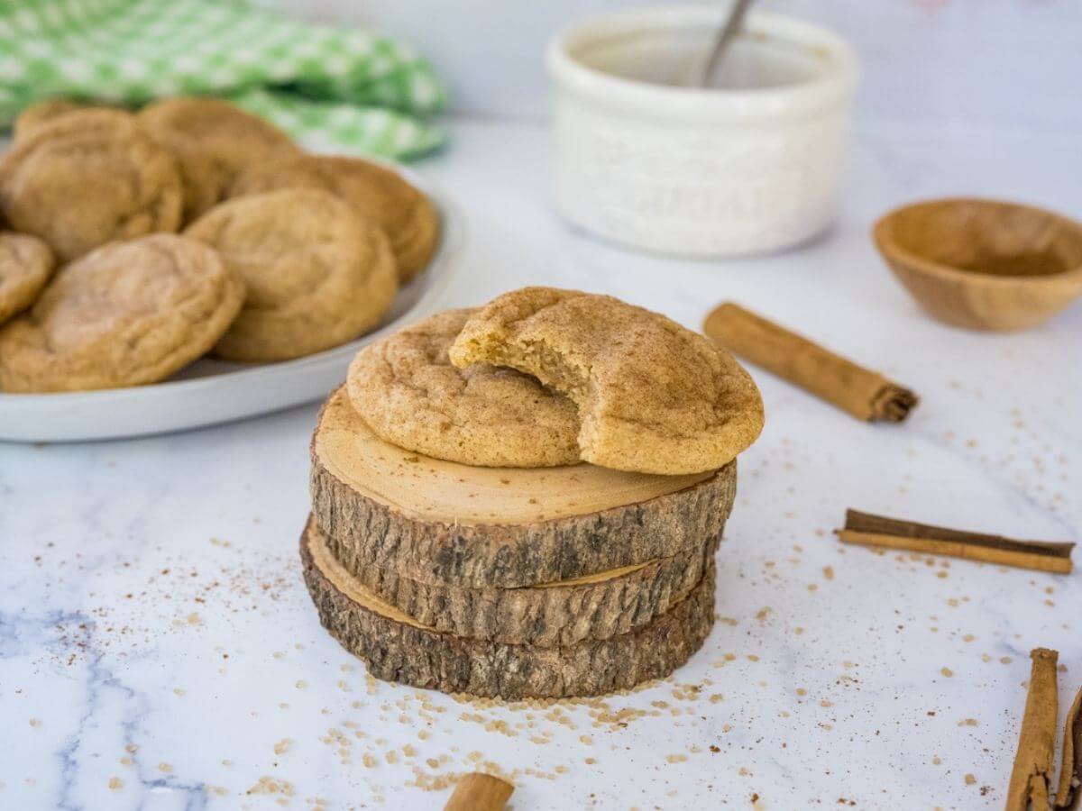 Snickerdoodles on a stack of wood with one cookie missing a bite.