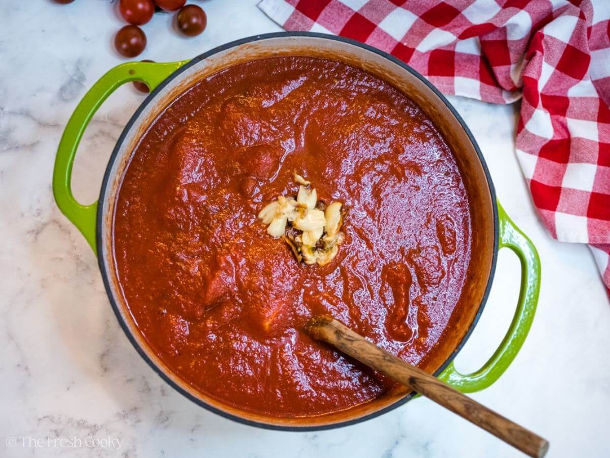 Adding in crushed tomatoes and roasted garlic.