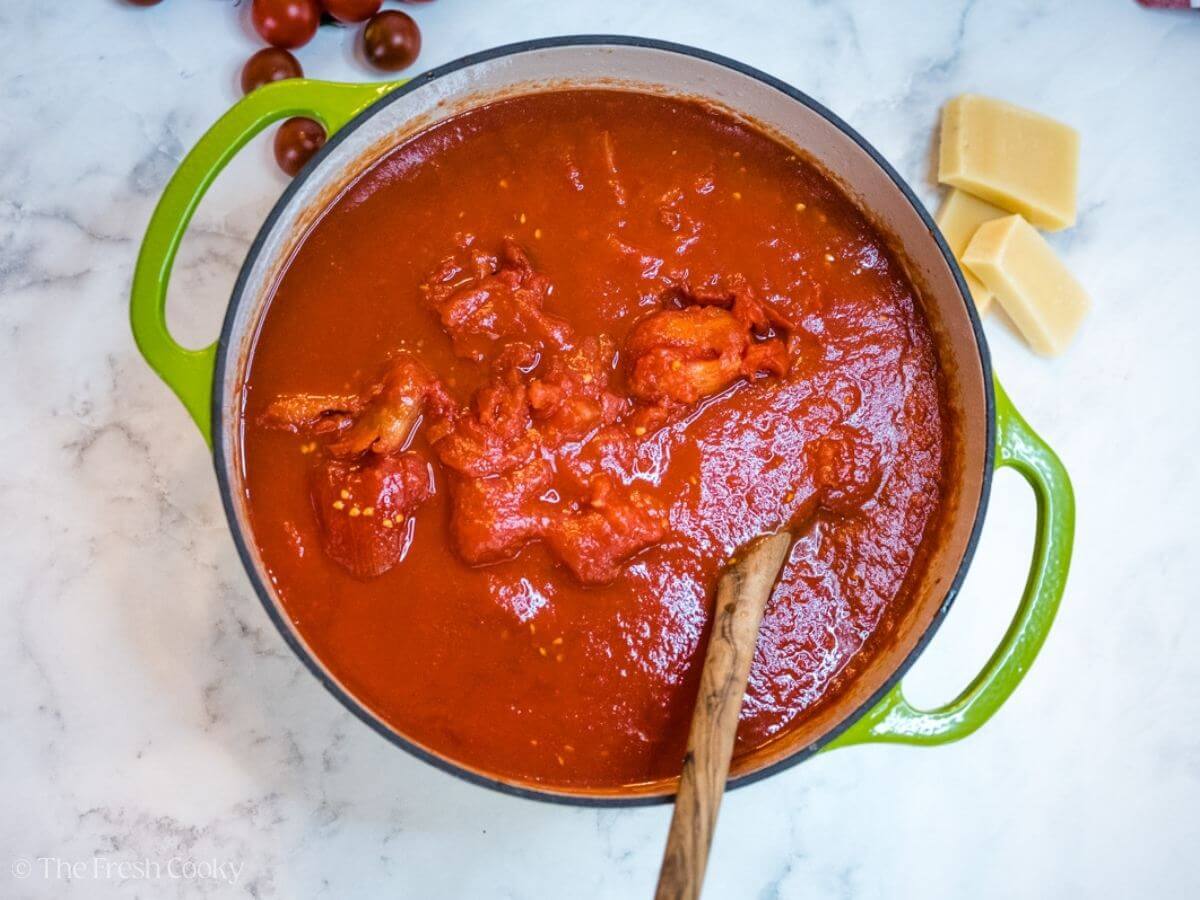 Add tomatoes to the pot, stirring in.