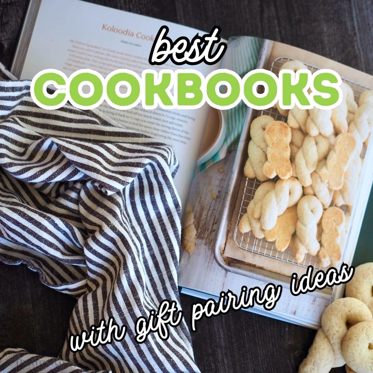 A cookbook with cookies showing with a kitchen towel.