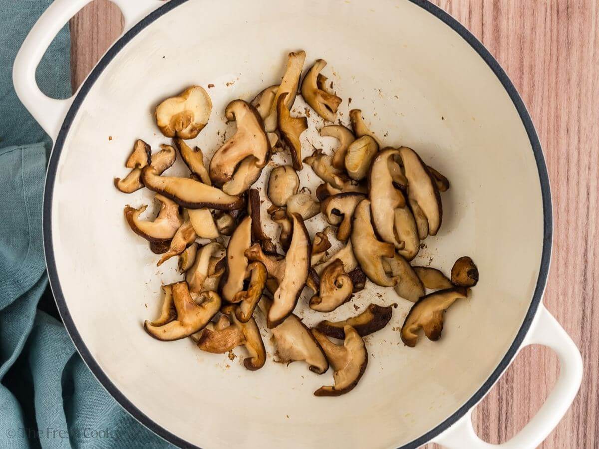 Mushrooms sautéing in a large stock pot.