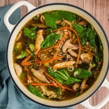 Vegetables and ramen noodles in chicken broth in a large Dutch oven.