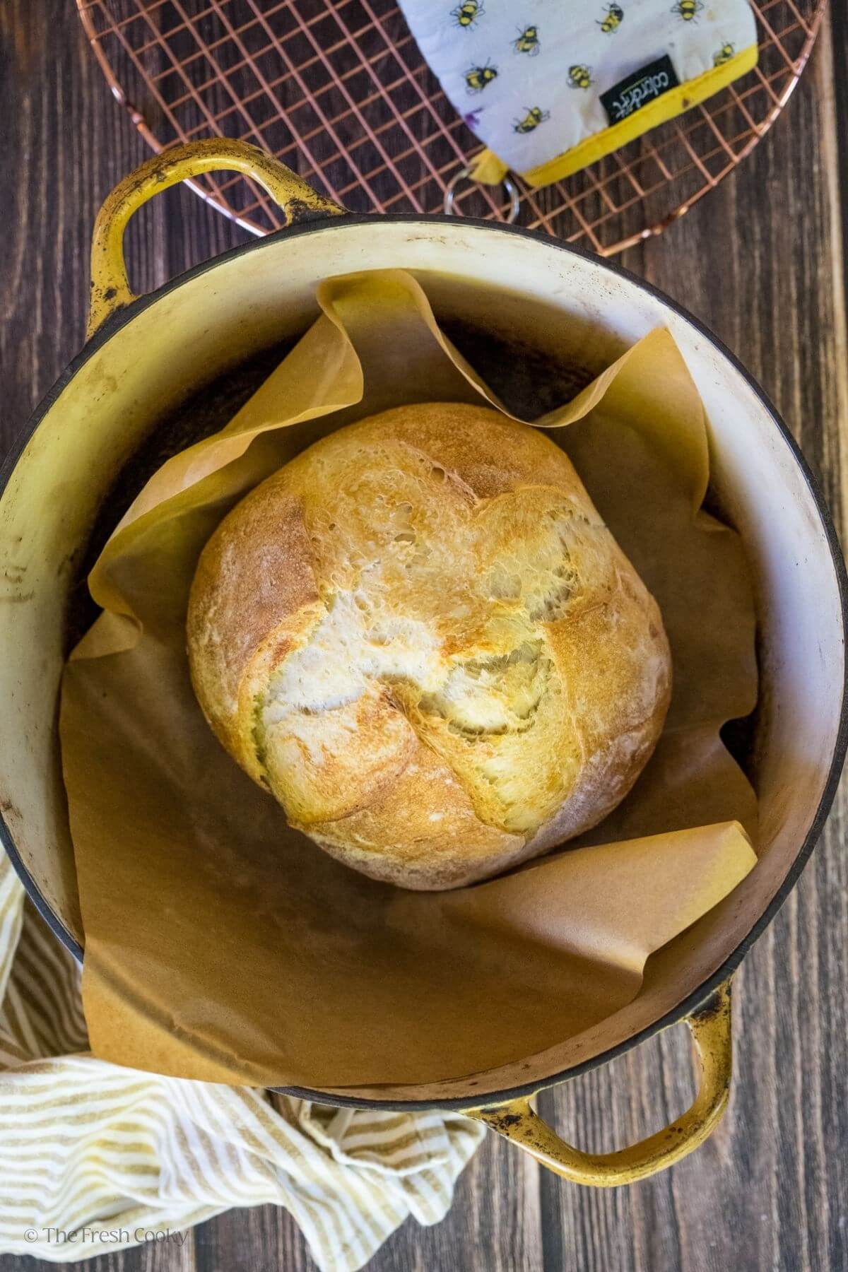 Sourdough bread loaf in a parchment lined Dutch oven.